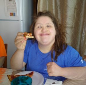 woman eating pizza and smiling