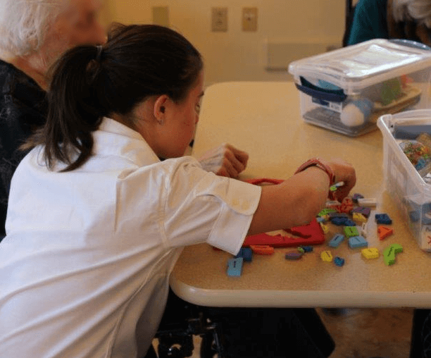 Thrive participant doing blocks with elderly person at nursing home